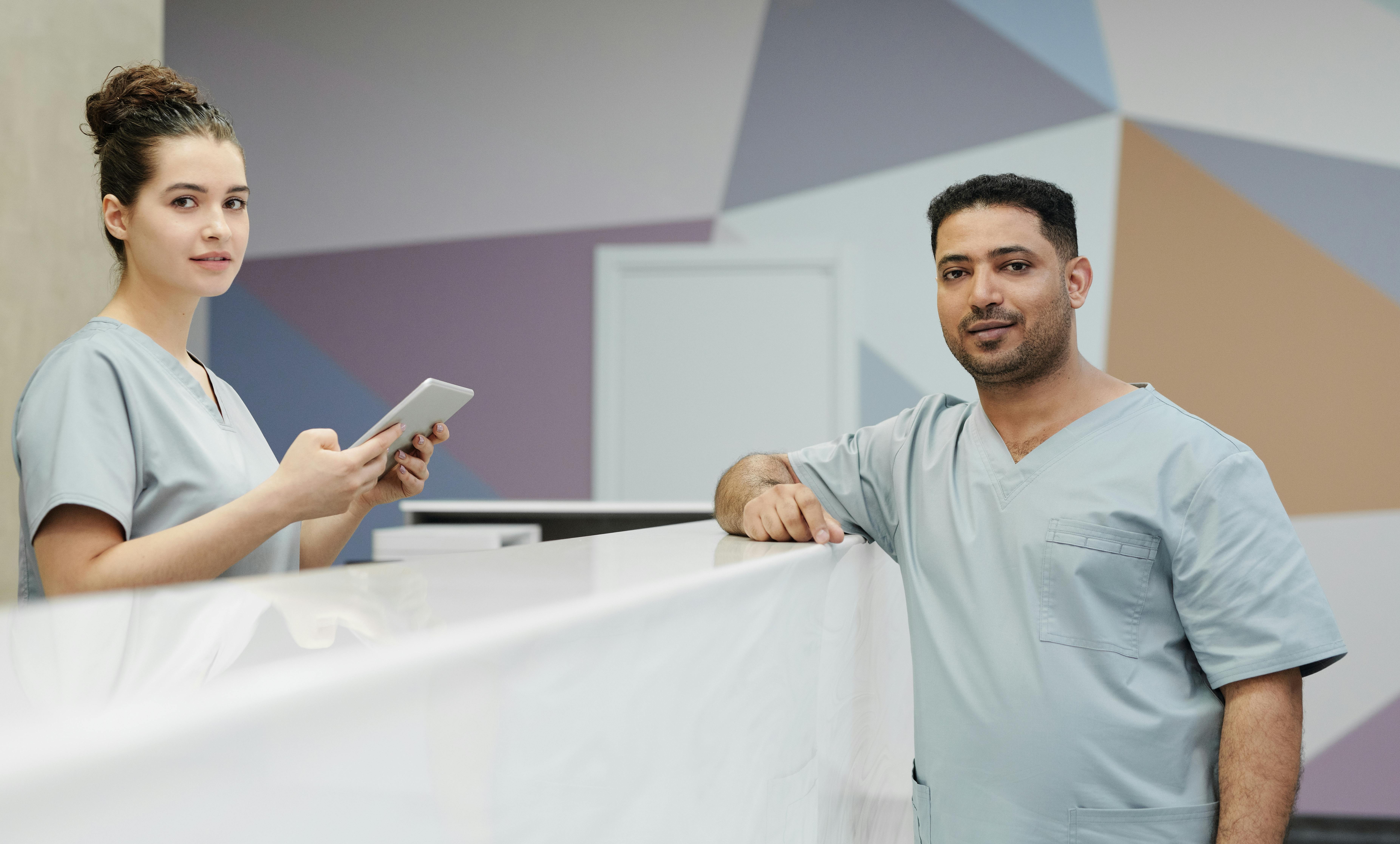 Recep&ccedil;&atilde;o de cl&iacute;nica com profissionais usando tablet